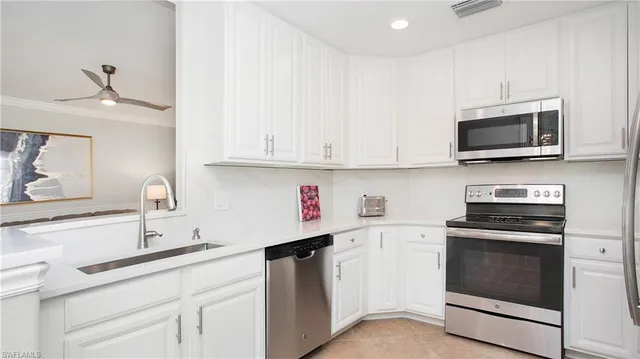 a kitchen with stainless steel appliances granite countertop white cabinets a sink and dishwasher