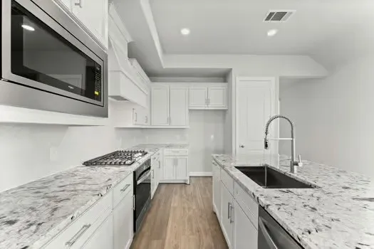 an empty room with wooden floor cabinet and windows