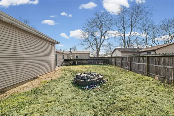 a view of a backyard with table and chairs and wooden fence