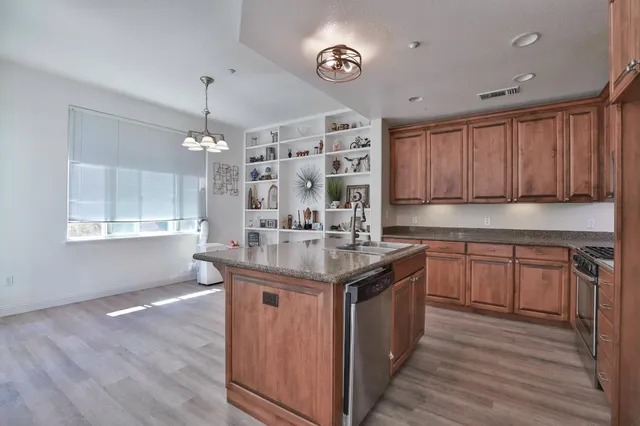 a kitchen with stainless steel appliances granite countertop a sink stove and cabinets