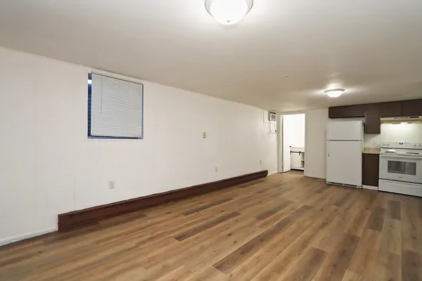 a view of empty room with wooden floor and window