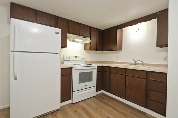 a kitchen with a refrigerator sink and cabinets