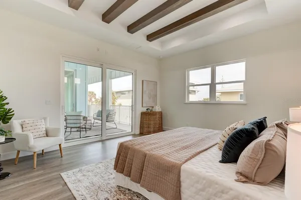 a bedroom with a large bed and wooden floor