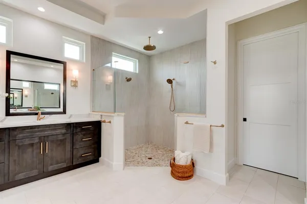 a bathroom with a double vanity sink a mirror and shower