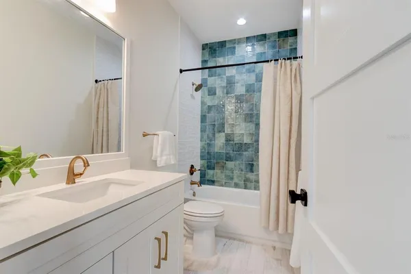 a bathroom with a sink toilet and shower