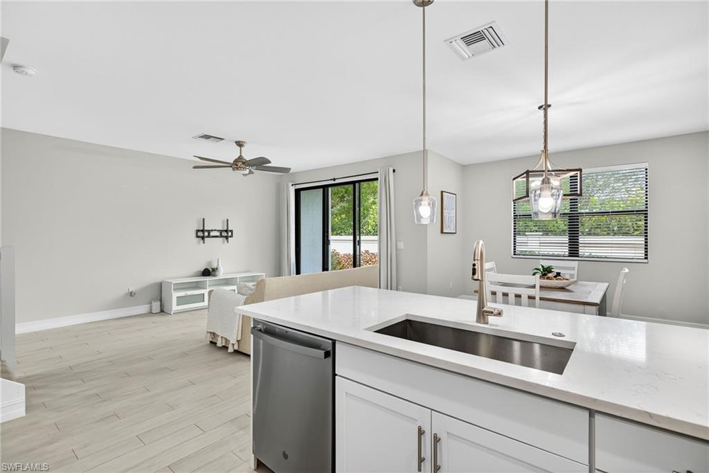 7570 Rockefeller Drive Naples, FL 34119 - Photo 11 of 34 a kitchen that has a sink cabinets and wooden floor