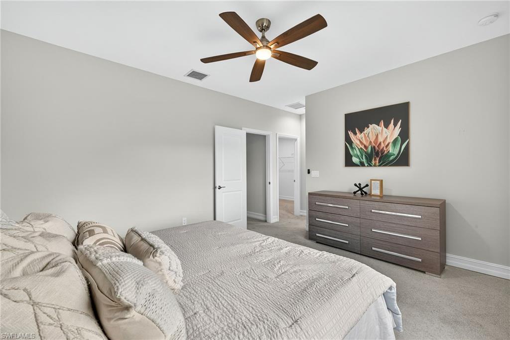 7570 Rockefeller Drive Naples, FL 34119 - Photo 15 of 34 a bedroom with a bed and a flat screen tv