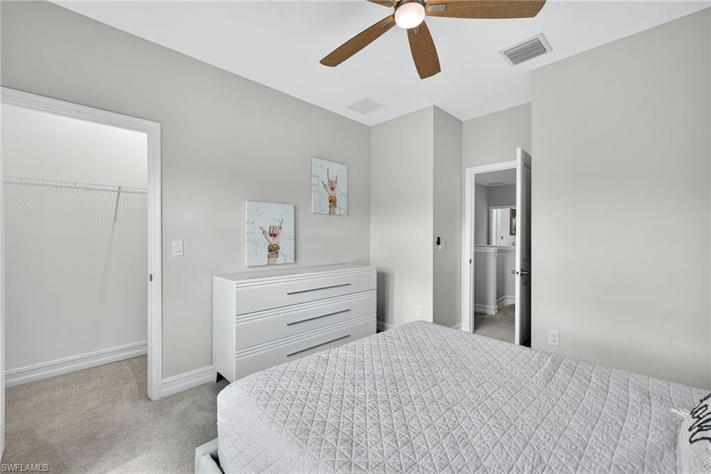 7570 Rockefeller Drive Naples, FL 34119 - Photo 18 of 34 a room with a bed and cabinets