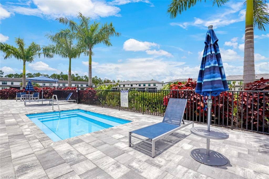 7570 Rockefeller Drive Naples, FL 34119 - Photo 31 of 34 a view of a swimming pool with a lounge chair and palm trees