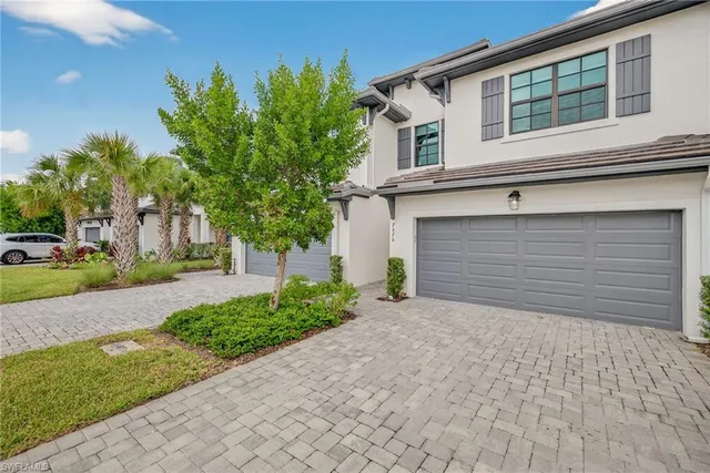 a front view of a house with a yard and a garage