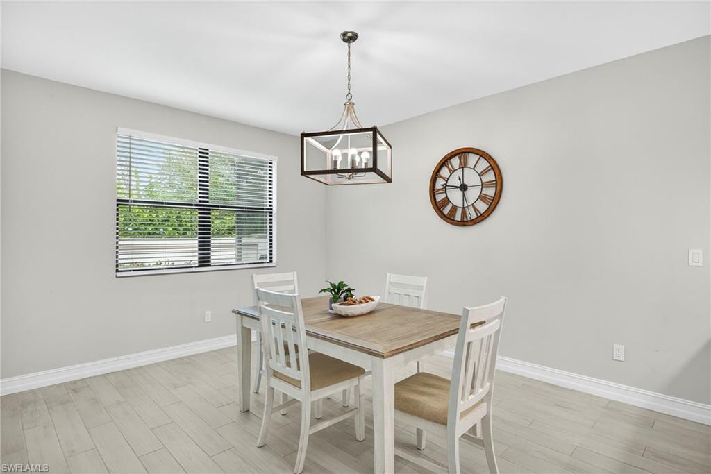 7570 Rockefeller Drive Naples, FL 34119 - Photo 9 of 34 a view of a dining room with furniture window and wooden floor
