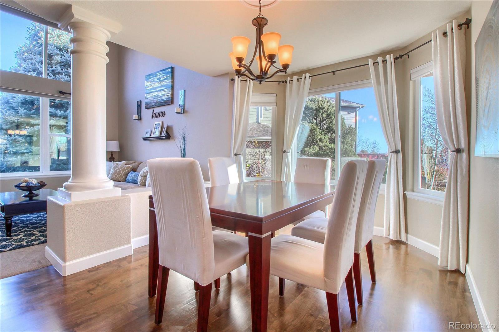 8952 Tuscany Lane Highlands Ranch, CO 80130 - Photo 4 of 32 a view of a dining room with furniture window and wooden floor