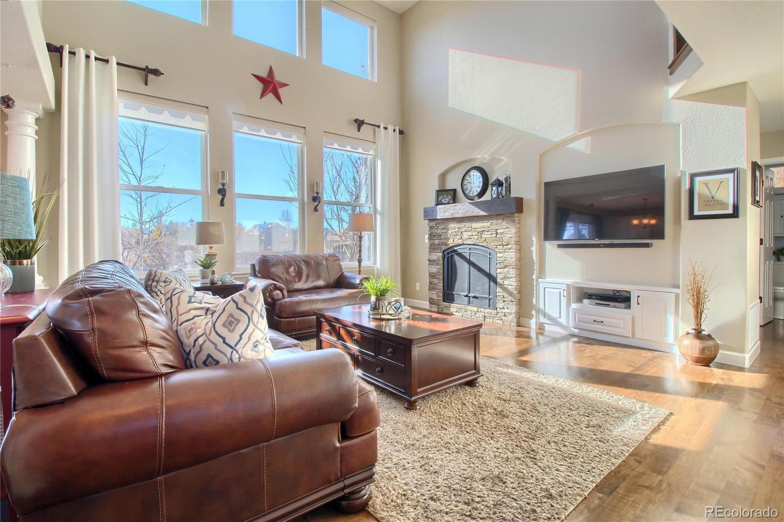 8952 Tuscany Lane Highlands Ranch, CO 80130 - Photo 6 of 32 a living room with fireplace furniture and a flat screen tv