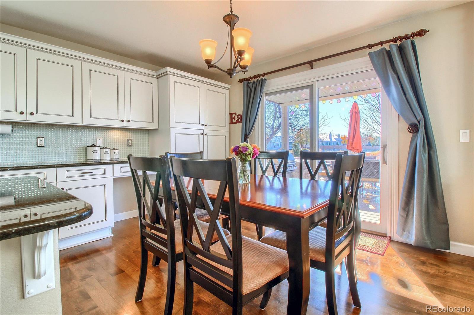8952 Tuscany Lane Highlands Ranch, CO 80130 - Photo 10 of 32 a view of a dining room with furniture window and wooden floor