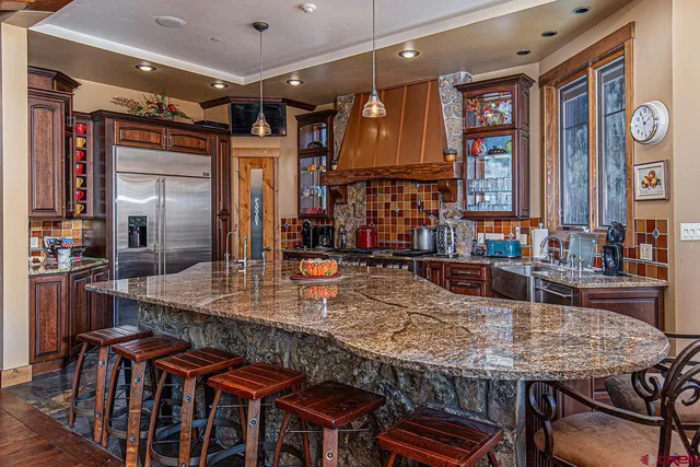 a kitchen with granite countertop a table chairs stove and cabinets