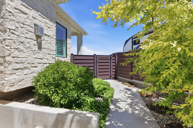 10676 Urban Rdg Cove South Jordan, UT 84095 - Photo 42 of 48 Stone veneer exterior with a contrasting brown privacy fence and gate