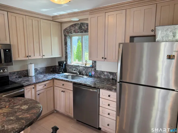 a kitchen with stainless steel appliances granite countertop a refrigerator sink and cabinets