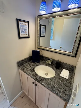a bathroom with a granite countertop sink a mirror and a toilet