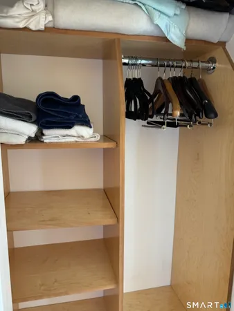 a view of an empty room and cabinet with mirror