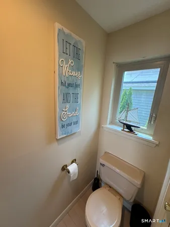 a bathroom with a toilet a sink and a window