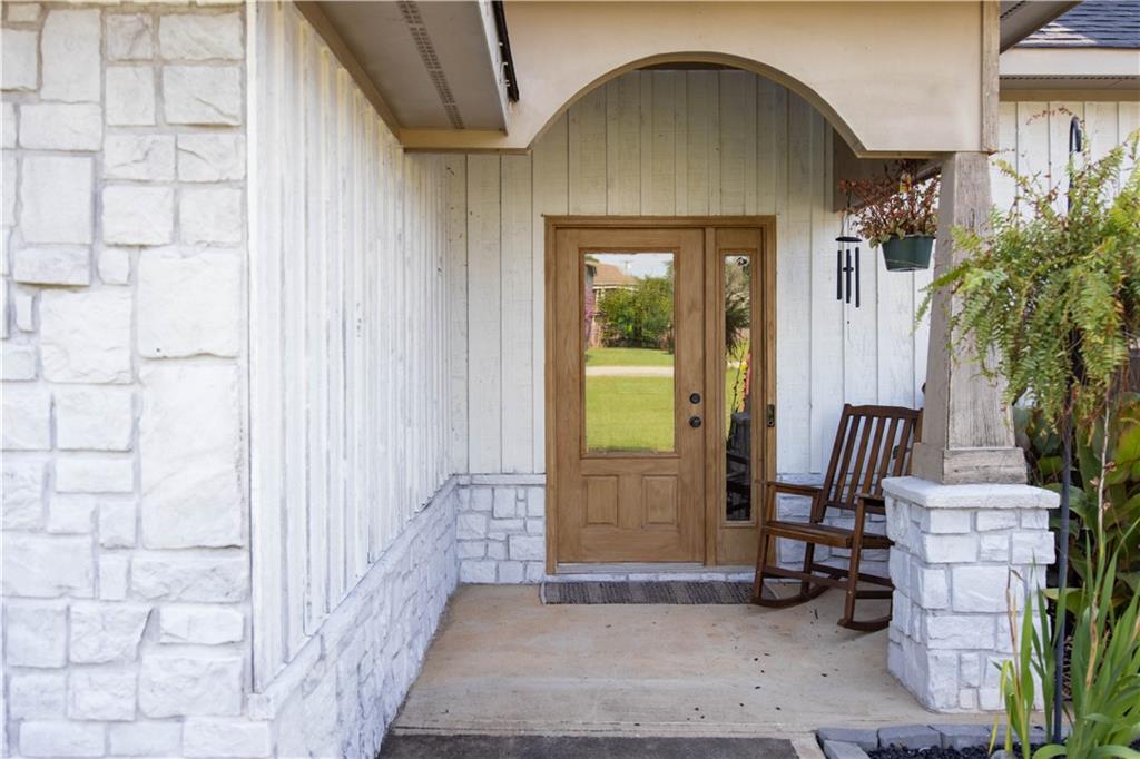 19 Isbell Road Fort Mitchell, AL 36856 - Photo 6 of 37 Stone and vertical siding exterior with wood-finish double entry doors, an arched entryway, and concrete porch