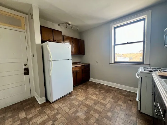 a kitchen with a refrigerator and a stove top oven