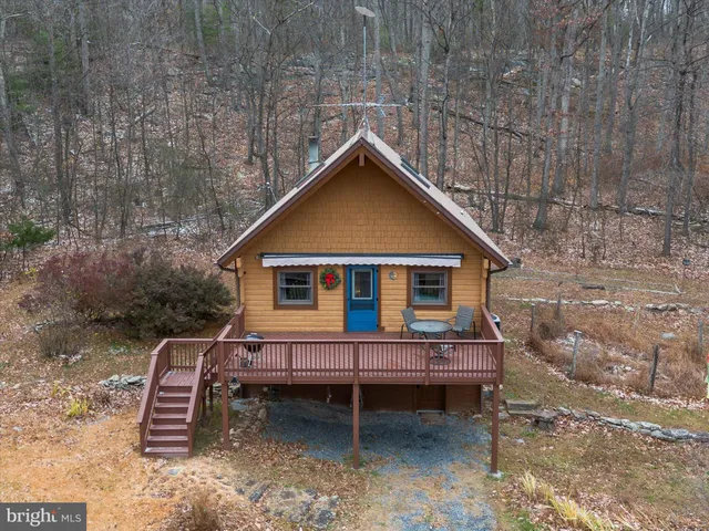 a backyard of a house with wooden deck and outdoor seating
