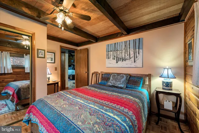 a bedroom with a bed a chandelier and a dresser