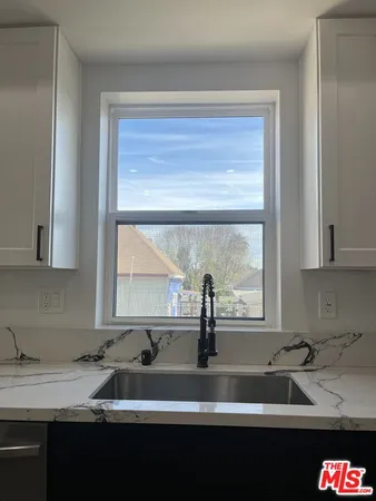 a kitchen with granite countertop a sink and a window