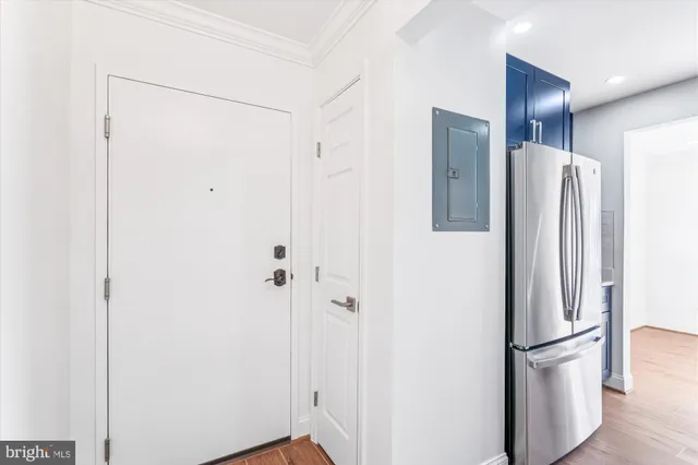 a view of bathroom with a refrigerator and wooden floor
