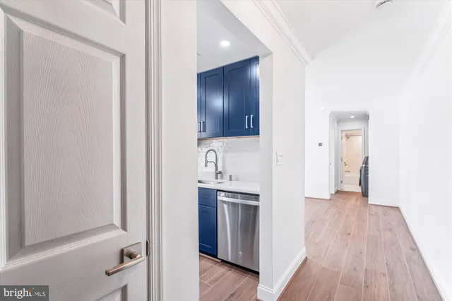 a view of a kitchen from the hallway with wooden floor