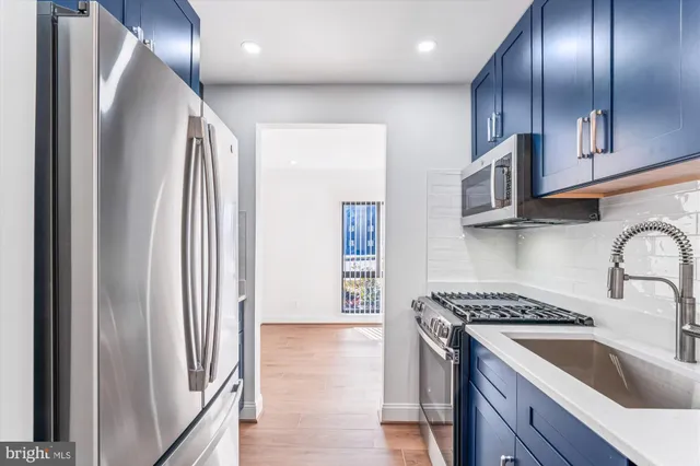a kitchen with stainless steel appliances granite countertop a refrigerator and a sink