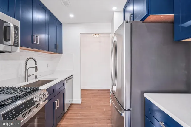 a kitchen with stainless steel appliances granite countertop a refrigerator and a stove