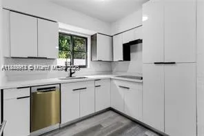 a kitchen with white cabinets and sink