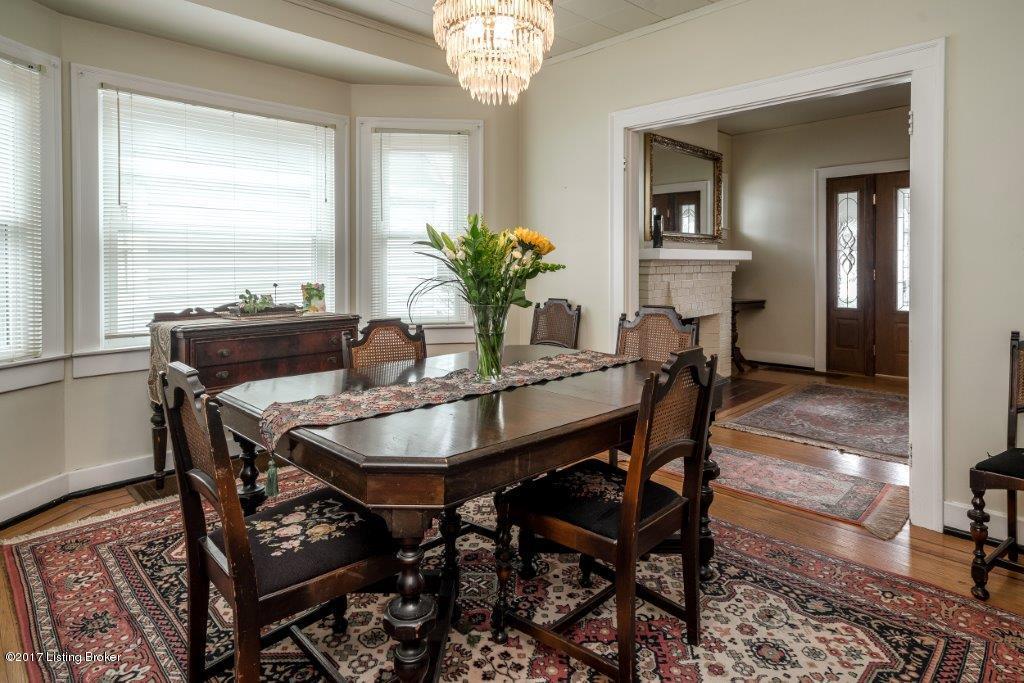 Banquet size dining room open to the front family room with lovely bay window, inlaid hardwood flooring and antique chandelier
