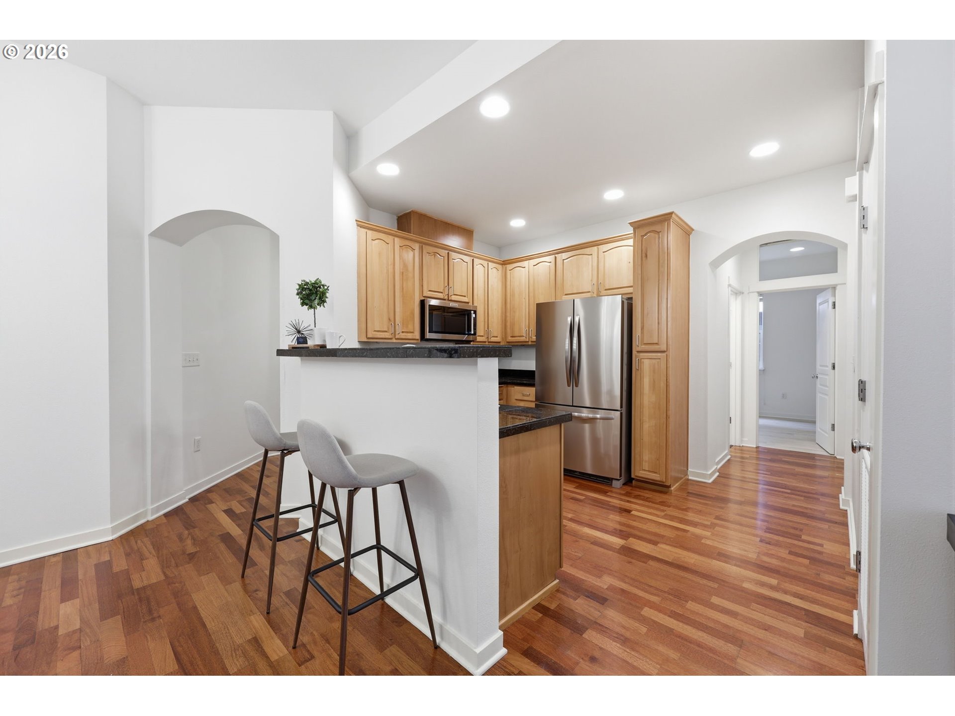 8361 Southwest 24th Avenue Portland, OR 97219 - Photo 12 of 39 a open kitchen with stainless steel appliances granite countertop a refrigerator a sink a stove and oven with wooden floor