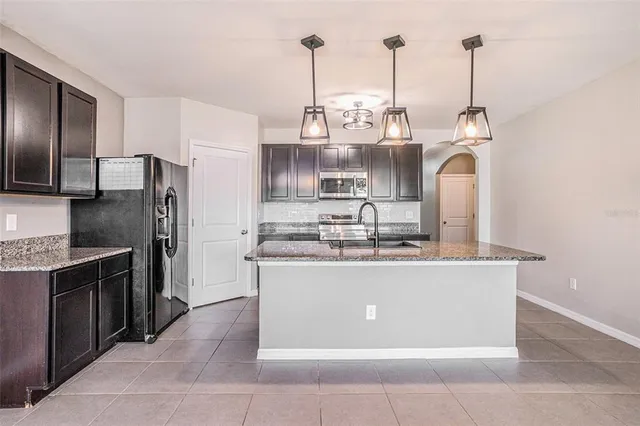 a kitchen with stainless steel appliances granite countertop a sink a stove and refrigerator