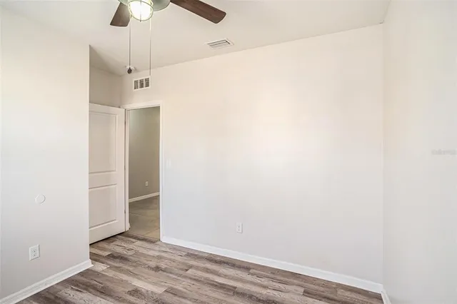 an empty room with a empty space and a ceiling fan