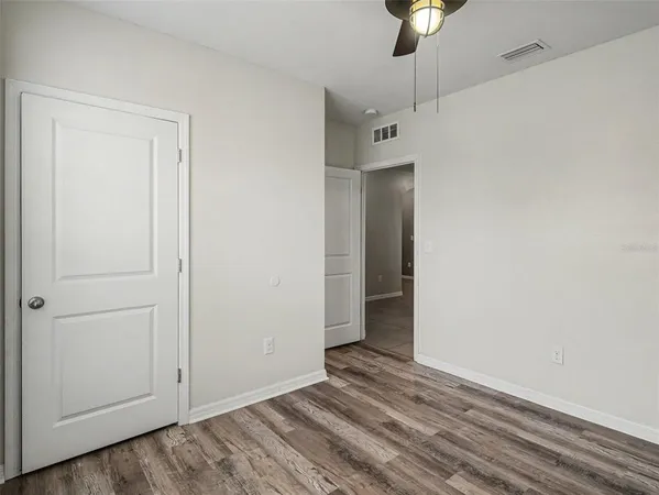 a view of an empty room with a chandelier fan