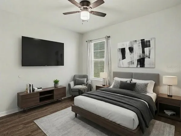 a bedroom with bed tv and window