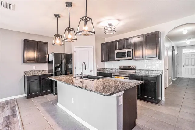 a kitchen with stainless steel appliances granite countertop a sink stove and refrigerator