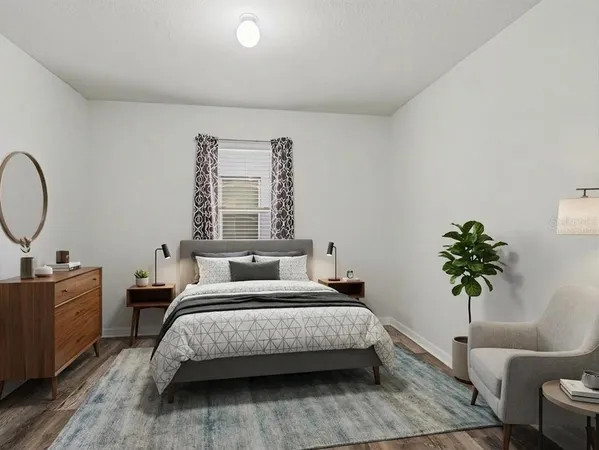 a bedroom with a bed a mirror and a potted plant