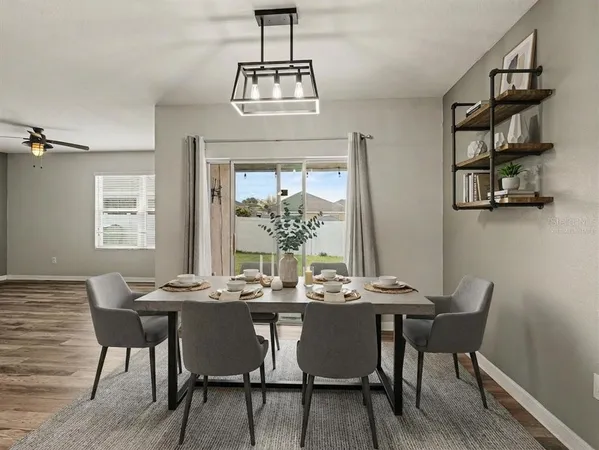 a dining room with furniture a chandelier and wooden floor
