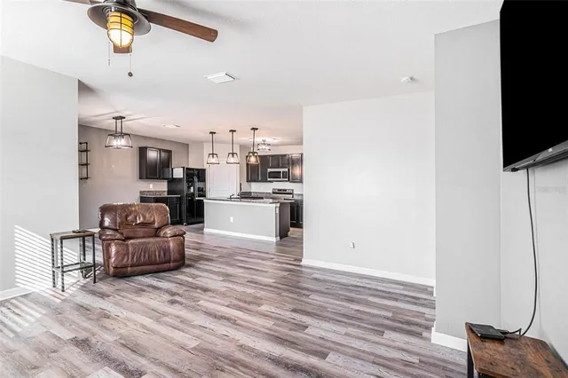 a living room with kitchen island furniture and a flat screen tv