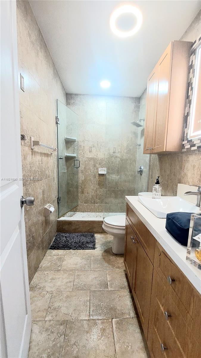 2145 Southwest 76th Avenue Miami, FL 33155 - Photo 14 of 28 a bathroom with a double vanity sink a toilet a mirror and bathtub