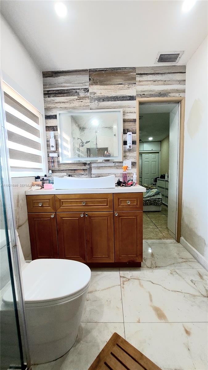2145 Southwest 76th Avenue Miami, FL 33155 - Photo 19 of 28 a bathroom with a sink a toilet and mirror
