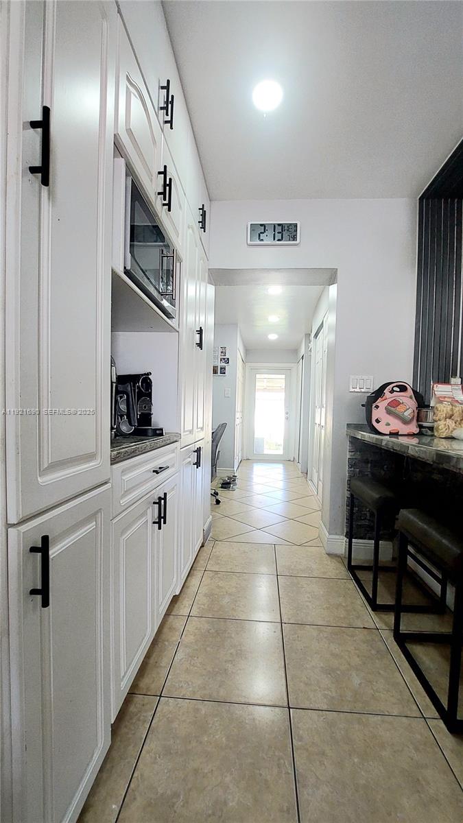 2145 Southwest 76th Avenue Miami, FL 33155 - Photo 23 of 28 a kitchen with stainless steel appliances kitchen island granite countertop a refrigerator and a sink