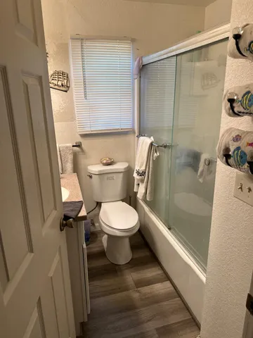 a bathroom with a granite countertop toilet sink and mirror