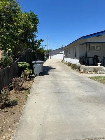 a backyard of a house with potted plants and a bench