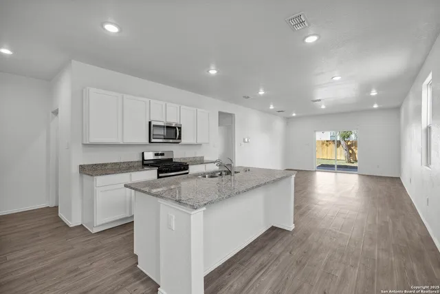 a kitchen with a sink and a stove top oven